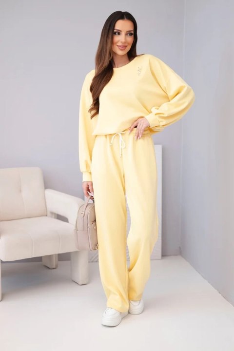 Komplet damski masełko bluza z broszką i spodnie z prostą nogawką ciemny żółty
